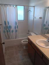 Bathroom with vanity, shower / bath combination with curtain, and tile patterned flooring