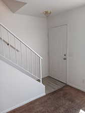 Carpeted entrance foyer with baseboards