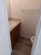 Half bathroom with vanity and wood finished floors