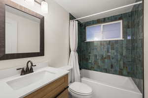 Bathroom with shower / bath combo with shower curtain, vanity, and a textured ceiling