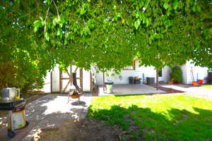 View of green lawn featuring a fire pit and a patio