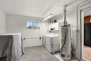 Washroom featuring water heater, cabinet space, a textured ceiling, wood walls, and light colored carpet