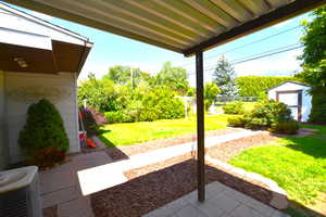 View of patio with a storage unit