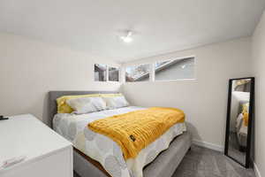 Bedroom featuring dark carpet and a textured ceiling