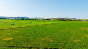 View of home's community with a rural view, a mountain view, and a yard