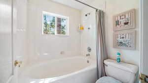 Bathroom featuring shower / bath combo and toilet