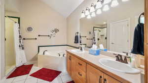 Master Full bath featuring a shower stall, vaulted ceiling, double vanity, a bath, and tile patterned floors