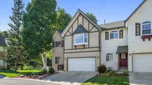 Swiss style home with concrete driveway, stucco siding, a garage, and a shingled roof