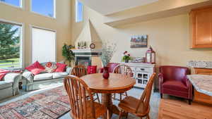 Dining space with a glass covered gas fireplace and a high ceiling