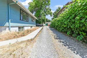 View of side of property featuring gravel driveway