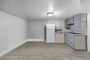 Unit C Kitchen with gray cabinetry, updated flooring
