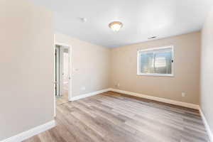 Unfurnished room with light wood-type flooring and baseboards