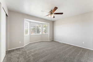 Unfurnished room with a ceiling fan and carpet