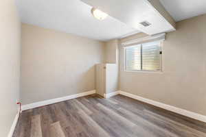 Empty room featuring wood finished floors and baseboards