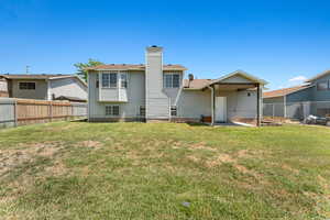 Rear view of property featuring a fenced backyard and a chimney