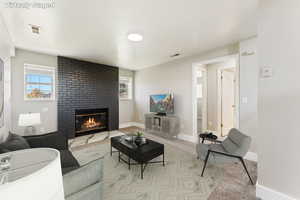 Living area with a brick fireplace and carpet flooring