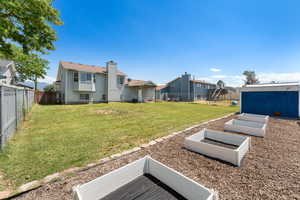 Fenced backyard featuring a garden and a residential view