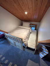 Carpeted bedroom featuring wood ceiling