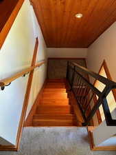 Stairway featuring wooden ceiling, vaulted ceiling, and recessed lighting