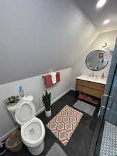 Bathroom with vaulted ceiling, vanity, a tile shower, and recessed lighting