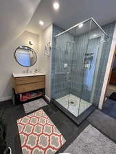 Full bathroom featuring vanity, a shower stall, lofted ceiling, and recessed lighting
