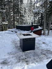 Yard covered in snow featuring a hot tub