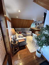 Living area featuring hardwood / wood-style floors, healthy amount of natural light, recessed lighting, and vaulted ceiling