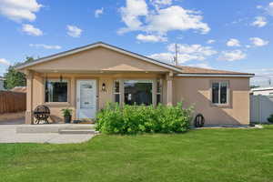Bungalow-style house featuring stucco siding and covered porch