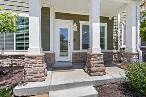 Doorway to property featuring covered porch