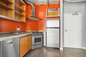 Kitchen with wall chimney range hood, appliances with stainless steel finishes, concrete flooring, open shelves, and brown cabinetry