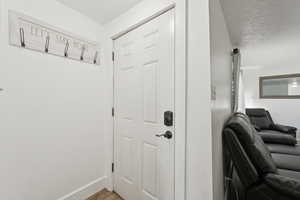 Mudroom featuring a textured ceiling and wood finished floors