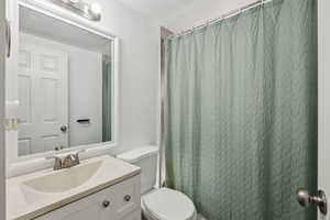 Full bathroom with vanity, a textured ceiling, and curtained shower