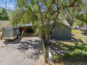 View of front of house featuring asphalt driveway and a carport