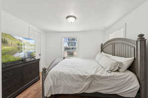 Bedroom with a textured ceiling and light wood-type flooring