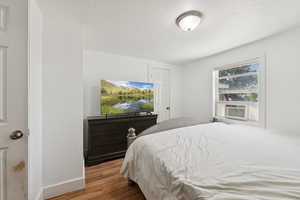 Bedroom featuring wood finished floors and a textured ceiling