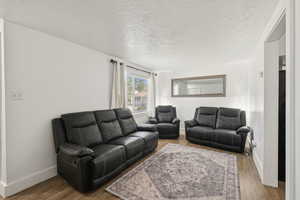 Living room featuring a textured ceiling and wood finished floors