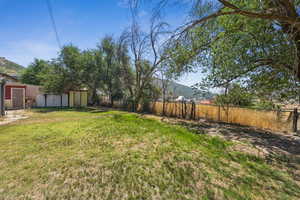 Fenced backyard featuring a storage shed