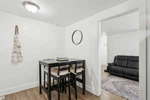 Dining area with a textured ceiling and wood finished floors