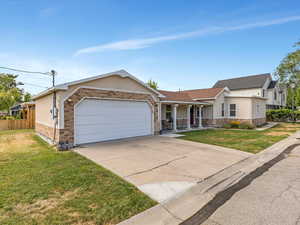 Ranch-style house featuring covered porch, a garage, concrete driveway, and stucco siding