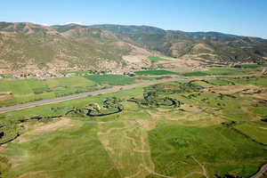 Aerial view of property and surrounding area featuring a mountain backdrop,