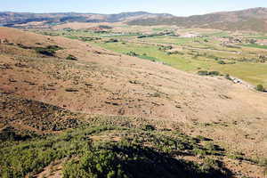 Aerial view of property's location featuring a mountain backdrop and rural landscape