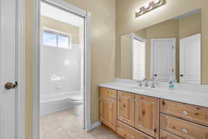 Bathroom with vanity, tile patterned floors, and tub / shower combination