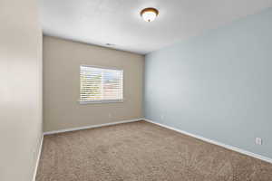 Carpeted spare room with baseboards