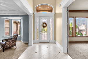 Foyer entrance with light colored carpet and light tile patterned flooring