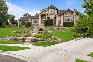 View of front facade with a front yard, brick siding, and roof with shingles