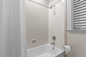 Full bathroom featuring shower / bathtub combination with curtain