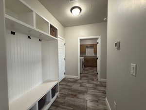 Mudroom featuring a textured ceiling and baseboards