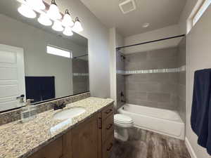 Full bathroom featuring vanity, wood finished floors, and  shower combination