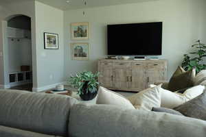 Living area featuring arched walkways and baseboards
