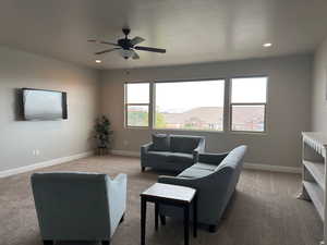 Living area with carpet floors, ceiling fan, plenty of natural light, and recessed lighting
